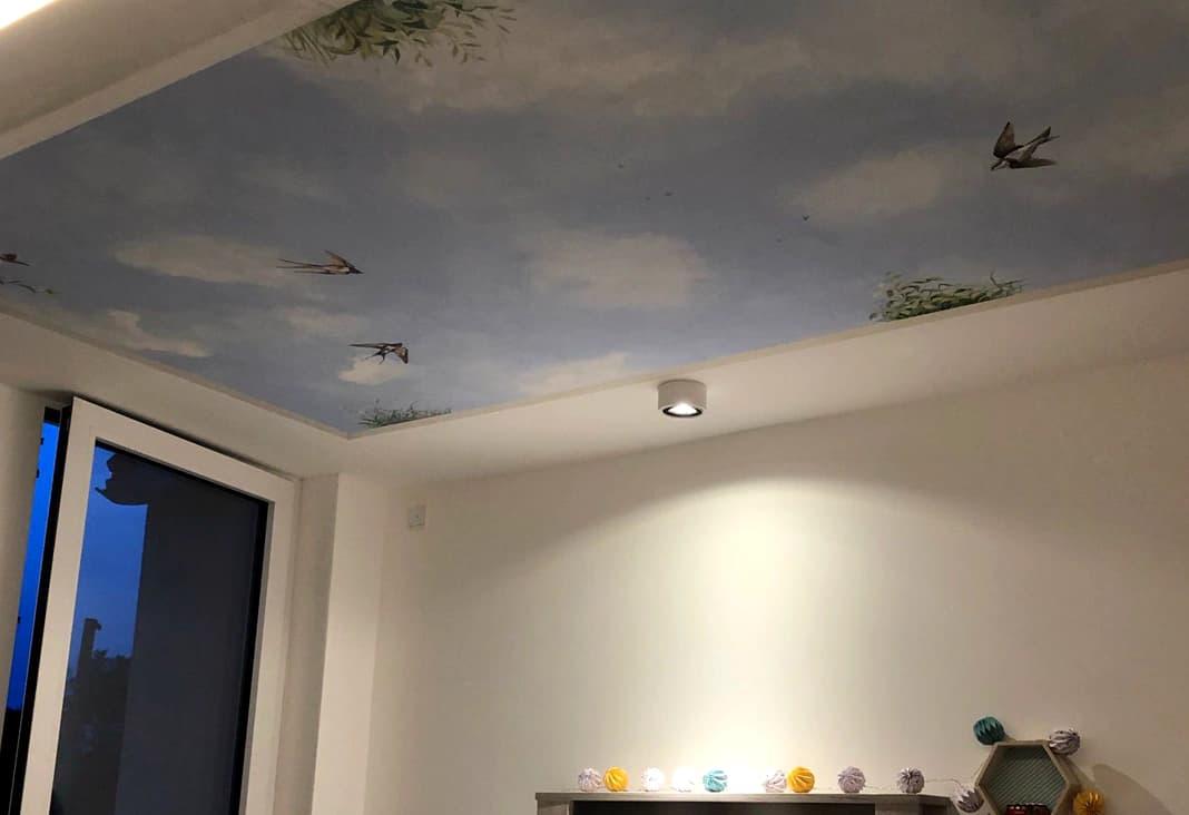 Deckenmalerei eines Himmels mit Schwalben im Kinderzimmer.