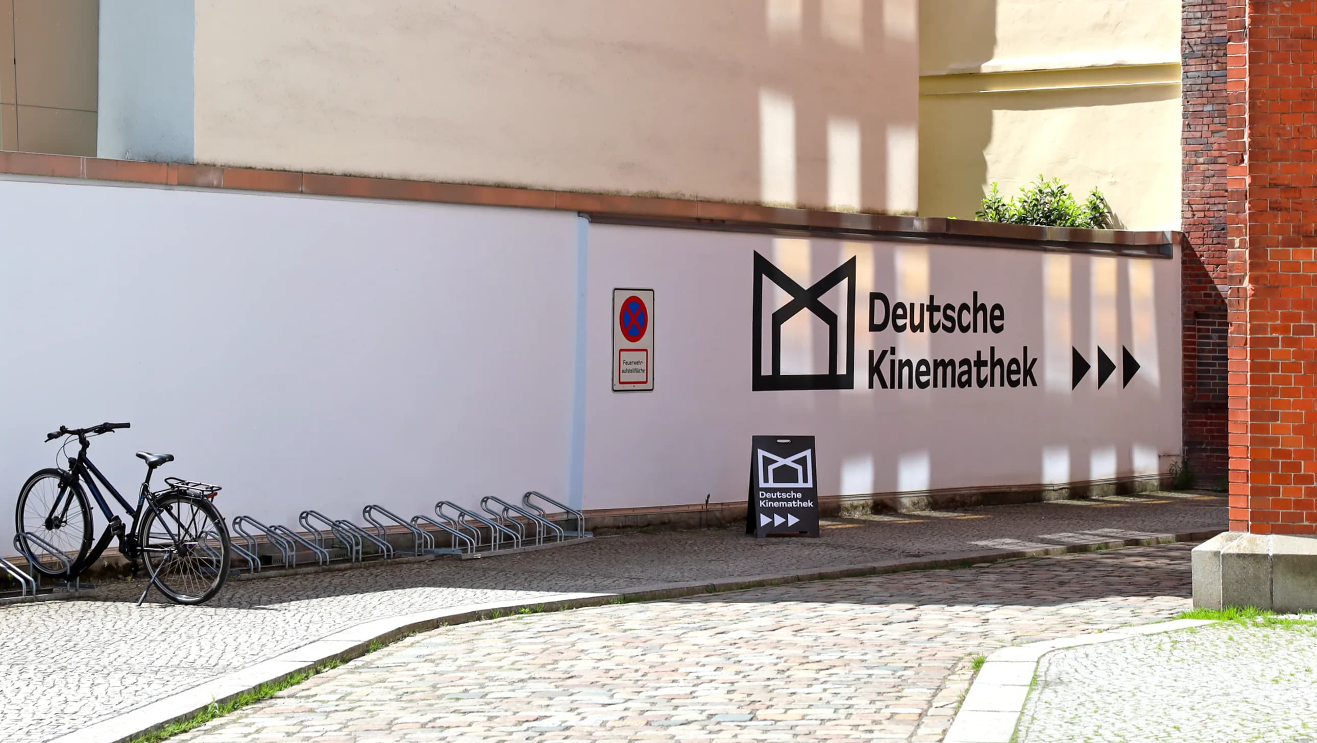 Professionelle Wandmalerei und Schriftgestaltung: Handgemaltes Kinemathek-Logo als kreative Fassadenkunst und Orientierungssystem.