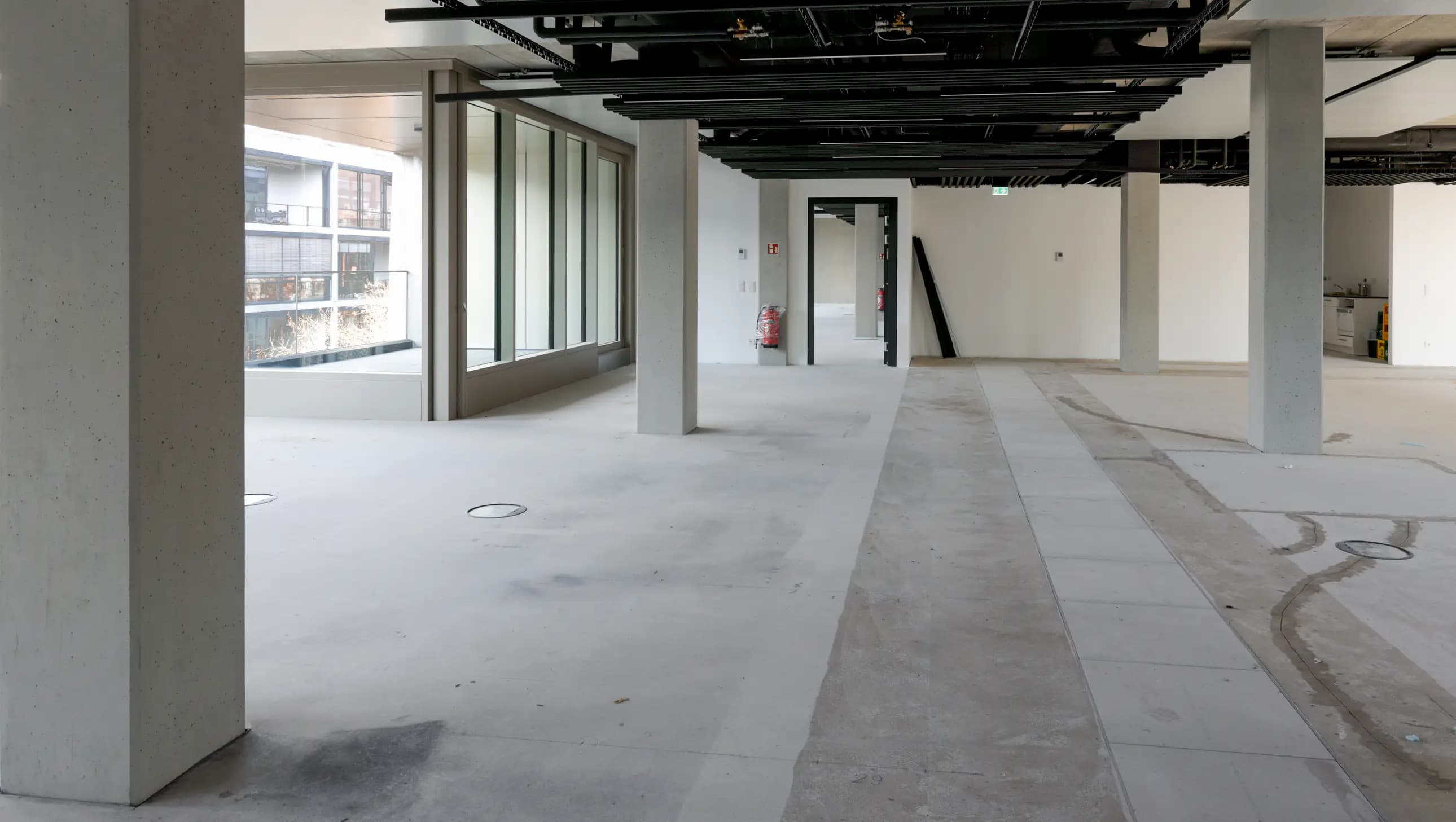 Moderner Sichtbeton im Innenraum von Pandion The Grid – Flur- und Treppenbereiche mit ästhetischer Sichtbetonkosmetik.