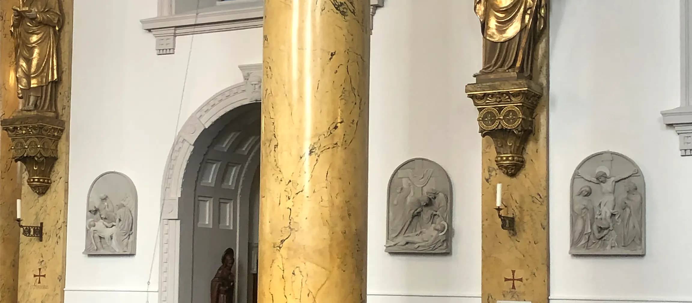 Kunstvoll erneuerte Reliefs in Sandsteinoptik im Innenraum der Kirche – detailgetreue Restaurierung mit historischem Charakter.